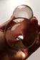 Designstudio Labim: Das Bild zeigt die Massagekugel "Lottchen" aus Glas mit zwei Segmenten, die von einer Person in der Hand gehalten wird. Man sieht das untere Ende der Kugel mit der besonders geformten Mulde, die an einen Apfel erinnert. Die Form eignet sich besonders für die Massage.